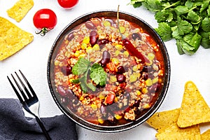 Chili con carne with minced beef, red beans, paprika, sweet corn and hot peppers in spicy tomato sauce, tex-mex cuisine dish,