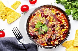 Chili con carne with minced beef, red beans, paprika, sweet corn and hot peppers in spicy tomato sauce, tex-mex cuisine dish,