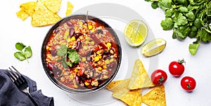 Chili con carne with minced beef, red beans, paprika, sweet corn and hot peppers in spicy tomato sauce, tex-mex cuisine dish,