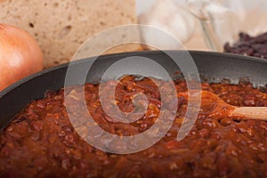 Chili Con Carne in pan on wooden table