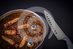 Chili cooking with fake human fingers and eyeballs