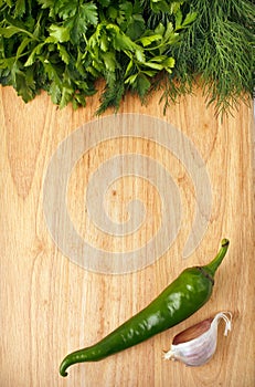 Chili, parsley and garlic on the wooden background