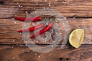 Chili pepper, salt and lime on a wooden board