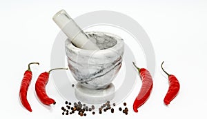 Chili pepper, stone mortar and pestle on white background