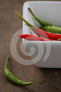 Chili pepper in white cup on wood table