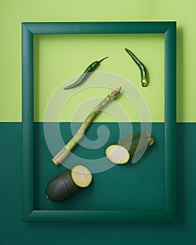 Chili peppers, zucchini, asparagus in green picture frame
