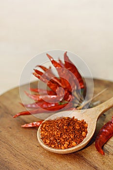 chili powder and dry chili peppers on wooden background.