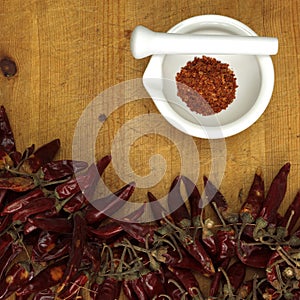 Chili powder in mortar with chillies, close-up