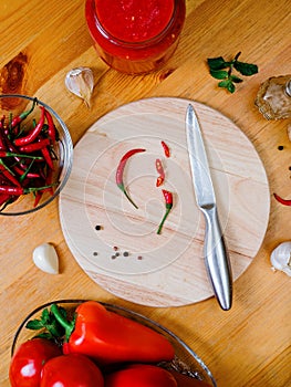 chili sauce preparation: small hot peppers on a round cutting board