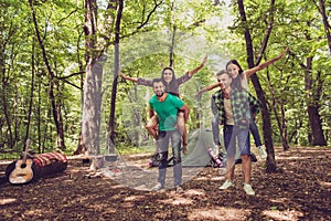 Chill, fun, joy, love and friendship! Four friends are fooling around in a wood at a campground, boys piggyback their ladies. Beau