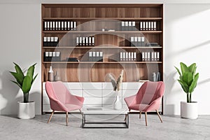 Chill space in business interior with armchairs, coffee table and shelf