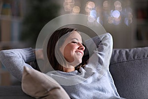 Chill woman relaxing in the sofa at home at night photo