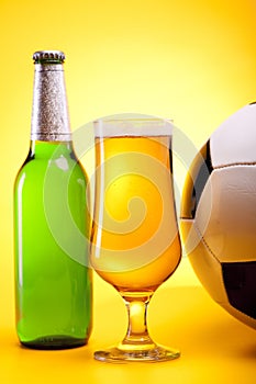 Chilled beer on yellow with ball