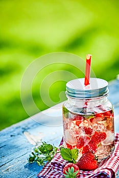 Chilled berry infused strawberry punch bowl in a glass jar