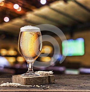 Chilled glass of light beer on old wooden table