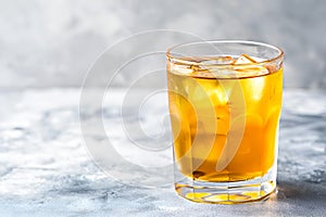 Chilled kombucha tea with ice cubes on light grey background, copy space. Cold kombucha drink in a glass. Iced kombucha beverage,