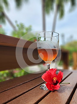 Chilled Tea in Wine Glass Next to Hibiscus Flower