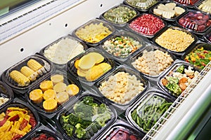 Chilled vegetables in plastic on shop counter