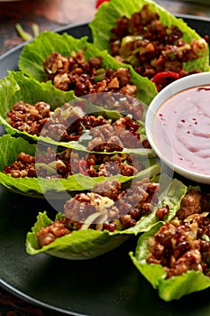 Chilli Beef Lettuce Wraps with sauce on black plate