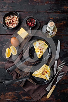 Chilli crab silky omlette , on frying iron pan, on dark wooden background, top view flat lay