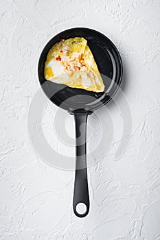 Chilli crab silky omlette , on frying iron pan, on white background, top view flat lay