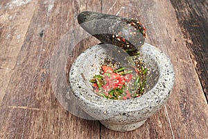 Chilli pepper in stone mortar on the wooden table