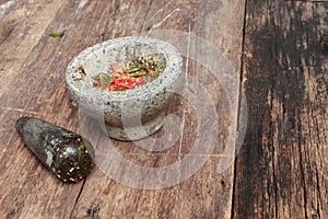 Chilli pepper in stone mortar on the wooden table