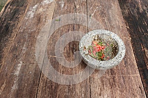 Chilli pepper in stone mortar on the wooden table