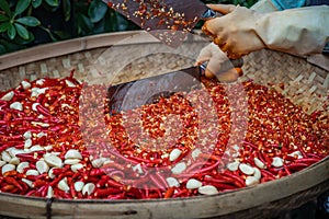 Chillies and garlic being chopped in a wicker bowl