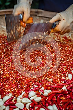 Chillies and garlic being chopped in a wicker bowl