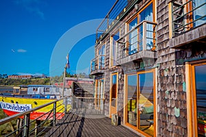 CHILOE, CHILE - SEPTEMBER, 27, 2018: View of beautiful colorful wooden restaurant cebiche on stilts palafitos, in a low