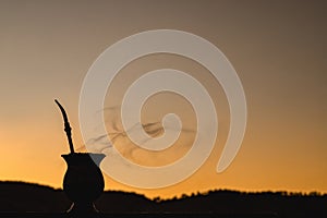 ChimarrÃ£o gourd at sunset, yerba mate infusion, served on cold winter days, gauchÃ¡ tradition, symbol drink of Rio Grande do Sul