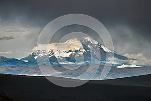 Chimborazo peak in the distance, dark clouds