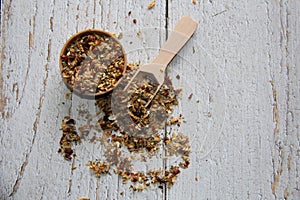 Chimichurri: dried in a wooden bowl with a wooden measuring spoon on a wooden table.