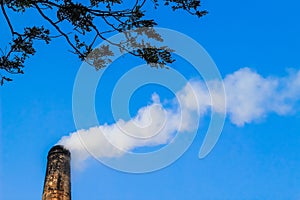 The chimney of brick field emitting heavy smoke with unhealthy carbon di oxide responsible for damaging ozone layer.