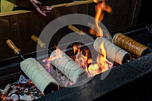 A chimney cake is baked over an open charcoal grill