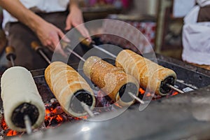 Chimney cake preparation. Chimney cake is being roasted over the fire. Street food concept