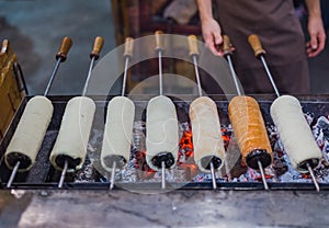 Chimney cake preparation. Chimney cake is being roasted over the fire. Street food concept