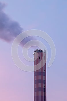 Chimney of an incineration plant, dawn windy morning