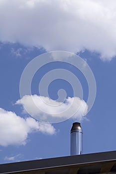 Chimney on the roof of the house against the blue sky