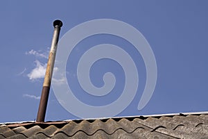 Chimney on the roof of the house against the blue sky