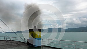 Chimney smoke on ferry boat in tropical sea. Ecological problems and global warming concept