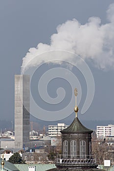 Chimney smoke with old town church spire