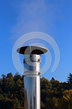 Chimney steel with polluting smoke coming out on a cold winter d