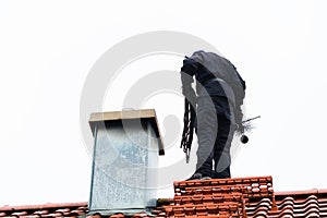 Chimney sweep on roof of home working