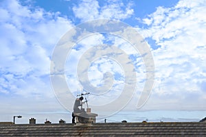 Chimney sweep at work on the rooftop photo