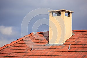 The chimney on top of a red roof