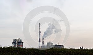 Chimneys of a coal power plant emitting clouds of steam into the atmosphere