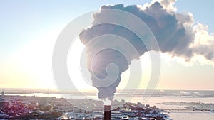 Chimneys of a factory or power plant produce smoke at sunrise, aerial view from a drone. The concept of ecological air