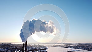 Chimneys of a factory or power plant produce smoke at sunrise, aerial view from a drone. The concept of ecological air